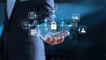 A businessman holds a holographic padlock surrounded by digital security symbols, representing cybersecurity and data protection.