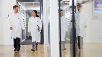 A man and a woman walk talking down a hallway A man and a woman walk talking down a hallway
