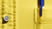 Stift in Brusttasche, gelbes Hemd.