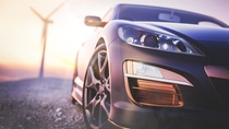 The image in front of the sports car scene behind as the sun going down with wind turbines in the back. The image in front of the sports car scene behind as the sun going down with wind turbines in the back.