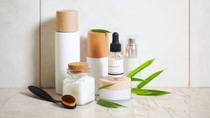 Face cream, serum, lotion, moisturizer and sea salt  among bamboo leaves in the bath