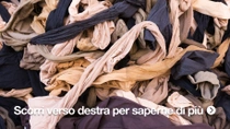 Primo piano di una grande pila di scampoli di tessuto di scarto in vari colori, aggrovigliati tra di loro.&nbsp;