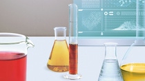 Many glass containers and test tubes with coloured liquids stand in front of a monitor on which scientific formulas can be seen. Many glass containers and test tubes with coloured liquids stand in front of a monitor on which scientific formulas can be seen.