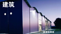 黄昏时分灯光亮起的现代建筑外观。图像上的文字为“建筑”。 