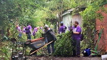 BASF employees work to clear brush and debris in a Detroit neighborhood alleyway. 