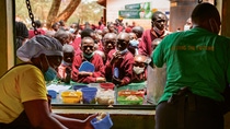 Two women from the food bank hand students their lunch.