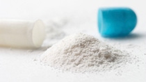 Close up of a pill with blue cap with small montain of white powder. Close up of a pill with blue cap with small montain of white powder.