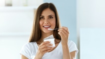 Healthy Lifestyle. Portrait Of Beautiful Sexy Smiling Woman Tasting Fresh Organic Yogurt. Charming Cheerful Girl On Diet Nutrition Eating Delicious Natural Yoghurt, Dairy Food. High Resolution Healthy Lifestyle. Portrait Of Beautiful Sexy Smiling Woman Tasting Fresh Organic Yogurt. Charming Cheerful Girl On Diet Nutrition Eating Delicious Natural Yoghurt, Dairy Food. High Resolution