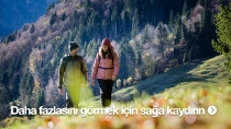 Güneşli bir günde bir erkek ve bir kadın, dağlık bir çayırda yürüyor. Üzerlerinde sıcak tutan dış mekân kıyafetleri var. Güneşli bir günde bir erkek ve bir kadın, dağlık bir çayırda yürüyor. Üzerlerinde sıcak tutan dış mekân kıyafetleri var.