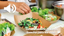 Primer plano de varios alimentos en recipientes de papel marrón. Se ve una mano preparando los alimentos.