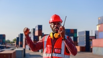 Engineer foreman, male African American, controls the inspection. Warehouse at container yard for international shipping business Moving industrial goods, logistics, import-export commercial transport