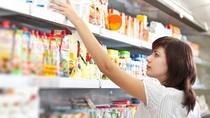 Woman in a grocery aisle picking out baby food  Woman in a grocery aisle picking out baby food