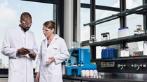 Two scientists discussing work in a lab  Two scientists discussing work in a lab