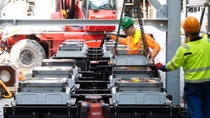 Am Haken: Der letzte Transformator wird per Kran in die Demonstrationsanlage gehoben und in Millimeterarbeit platziert und ausgerichtet. Am Haken: Der letzte Transformator wird per Kran in die Demonstrationsanlage gehoben und in Millimeterarbeit platziert und ausgerichtet.