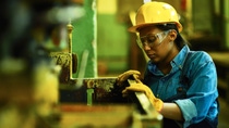 Female worker looking at container Female worker looking at container
