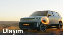 Gün batımında çöl manzarasında duran açık renkli bir SUV, ön tekerleğinin üzerinde parlak bir ışık halkası efektiyle görülüyor. Metinde “Ulaşım.” yazıyor.