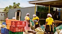 Women workers sort and weigh grain and other food, often from local farmers.