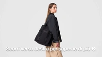 Una modella indossa una borsa nera sulla spalla davanti a uno sfondo neutro.