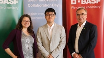Three people standing in front of 3 BASF banners
