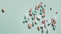 Various pills scattered on a pastel green background Various pills scattered on a pastel green background
