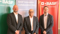 Three people standing in front of BASF banners