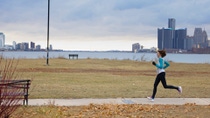 Woman running in front of a river and skyline