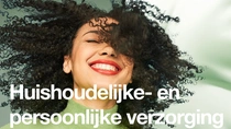 Een glimlachende vrouw met zwart krullend haar. De tekst op de afbeelding luidt: "Huishoudelijke- en persoonlijke verzorging."