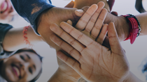 People of different origins and skin color put their hands on top of each other