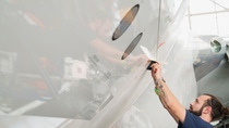 Der funktionale Film NovaFlex SharkSkin wird in einzelnen Stücken manuell auf die Oberfläche des Flugzeugs aufgebracht. Der funktionale Film NovaFlex SharkSkin wird in einzelnen Stücken manuell auf die Oberfläche des Flugzeugs aufgebracht.