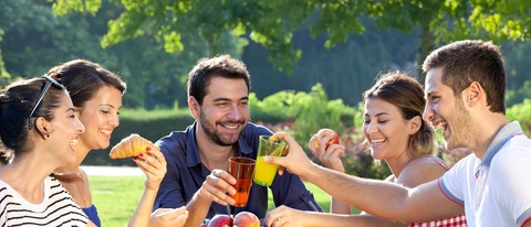 Group of people laughing and having a picnic cheer-sing cups 