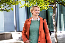 A woman in an orange coat smiling.  A woman in an orange coat smiling.