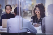 A diverse group of employees participates in a meeting, sharing ideas and perspectives in a collaborative and inclusive work environment.