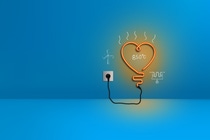 Looking up from the ground at a tall wind turbine against a clear blue sky – scientific equations and sketches highlighting the path of the wind are overlaid on the picture. 