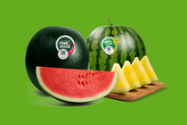 Zwei ganze, dunkelgrüne Ping Doce Wassermelonen und einige, in rote und gelbe Scheiben geschnittene Wassermelonen Zwei ganze, dunkelgrüne Ping Doce Wassermelonen und einige, in rote und gelbe Scheiben geschnittene Wassermelonen