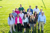 A diverse group of people put their hands over each other with motivation.