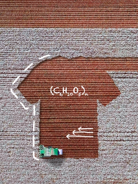 L’image correspond à une vue aérienne d’un champ de coton, où fonctionne une récolteuse. Le sol où le coton a été récolté à la forme d’un t-shirt. L’image comporte des croquis manuscrits blancs sur l’image représentant des formules scientifiques et trois flèches. 