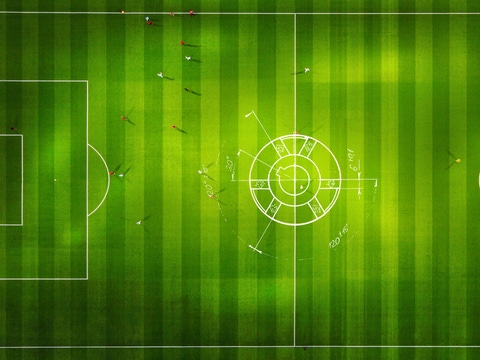 Luftaufnahme eines Fußballfeldes und von Fußballspielern. In der Mitte befindet sich die Skizze einer Wärmepumpe, um deren enorme Größe aufzuzeigen.