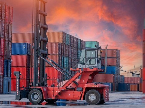 Crane lifting up container and unloading cargo into the import-export zone in yard. Crane lifting up container and unloading cargo into the import-export zone in yard.