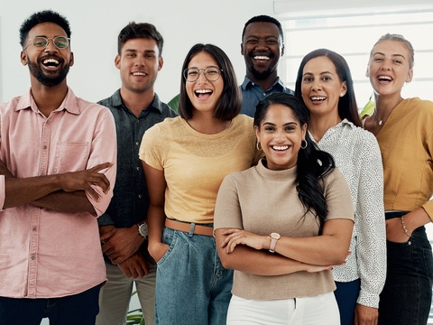 Eine Gruppe junger Talente steht in einem hellen Büroraum und lächelt in die Kamera.