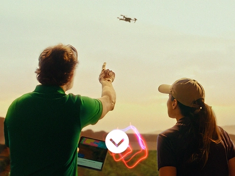 Two farmers flying a drone