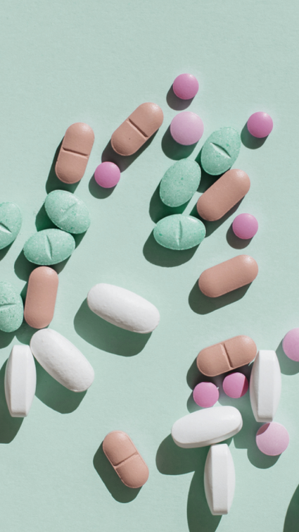 Bunte Pillen über einen grünen Hintergrund verstreut