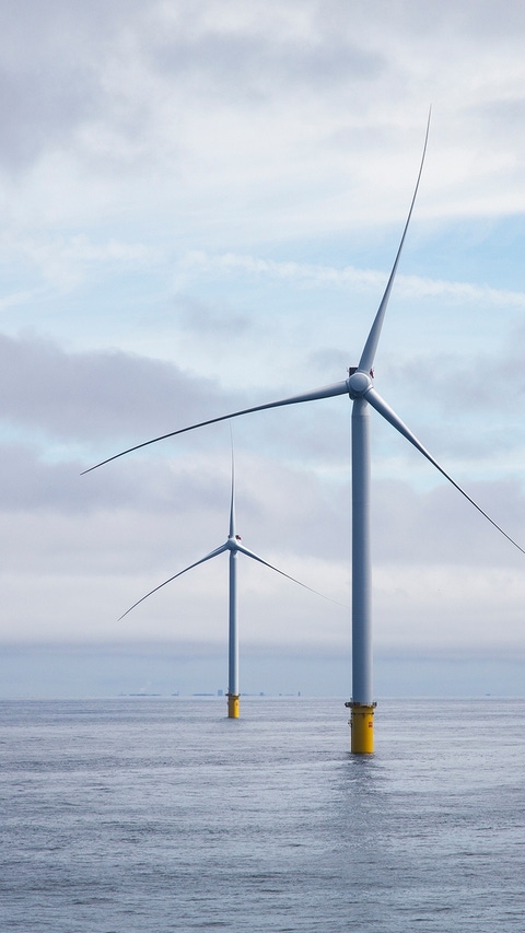 Zwei Windräder im blauen Ozean. 