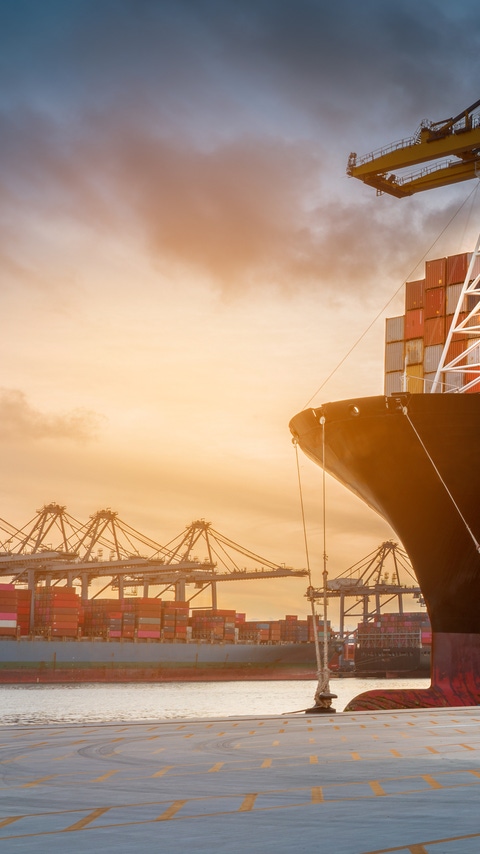 crane loading cargo container from truck to container ship in the international terminal logistic sea port concept freight shipping by ship 