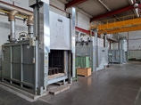 Innenraum eines industriellen Thermoofens mit feuerfest ausgekleideten Wänden und Metallschienen.