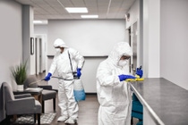 Two people in protective workwear cleaning and disinfecting offices. Two people in protective workwear cleaning and disinfecting offices.