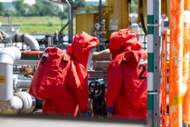In speziellen Chemikalienschutzanzügen dichten zwei Werkfeuerwehrmänner in der Übung eine defekte Flanschverbindung ab.
