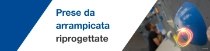 Primo piano di una presa di arrampicata blu su una parete interna, con uno scalatore sfocato sullo sfondo.