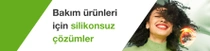 Siyah kıvırcık saçlı gülümseyen bir kadın. Resimdeki metinde şunlar yazıyor: “Bakım ürünleri için silikon içermeyen çözümler.”