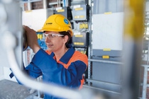 Female engineer in BASF-branded protective clothing and helmet looks into a piece of equipment at BASF’s methane pyrolysis test facility in Ludwigshafen. Female engineer in BASF-branded protective clothing and helmet looks into a piece of equipment at BASF’s methane pyrolysis test facility in Ludwigshafen.