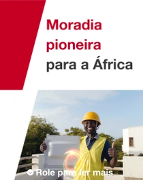 Um homem vestindo um colete de segurança amarelo e um capacete está do lado de fora, em frente a um prédio, segurando uma telha de construção. Redemoinhos de luz aparecem perto da mão da pessoa. O texto diz: “Moradia pioneira para a África”.
